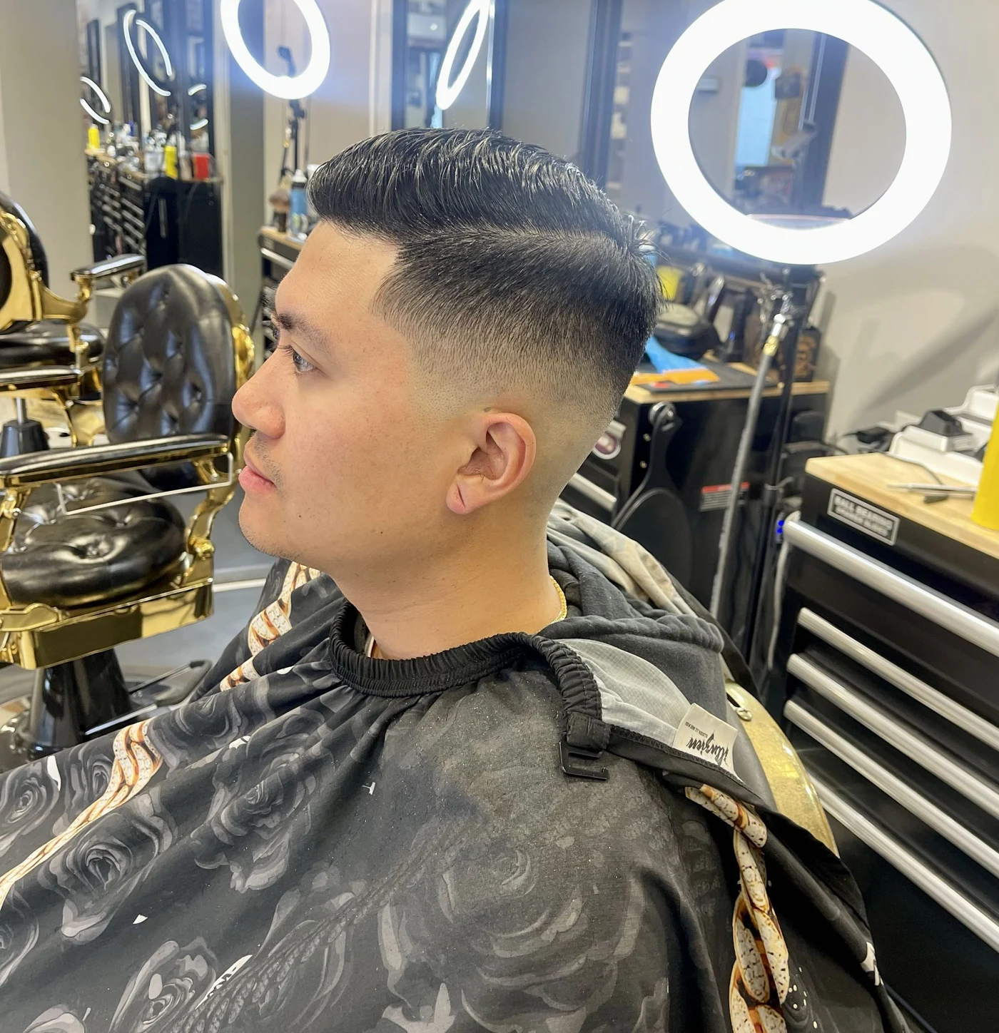 Side view of a classic haircut with a close fade and a neatly combed top by Tyler